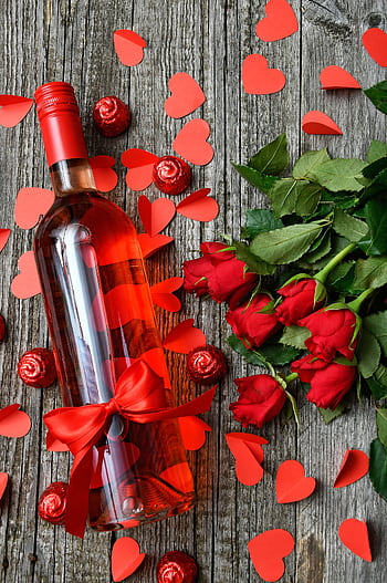 A romantic setup featuring red wine, roses, and heart cutouts, perfect for Valentine's Day celebrations. HD phone wallpaper