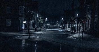 A quiet and dimly lit urban street scene at night, capturing the serene ambience. HD wallpaper