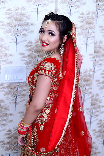 Beautiful South Asian bride in a traditional red saree with intricate gold embroidery. HD phone wallpaper