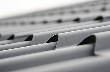 Detailed close-up of grey metal roof sheets showcasing texture and design. HD wallpaper