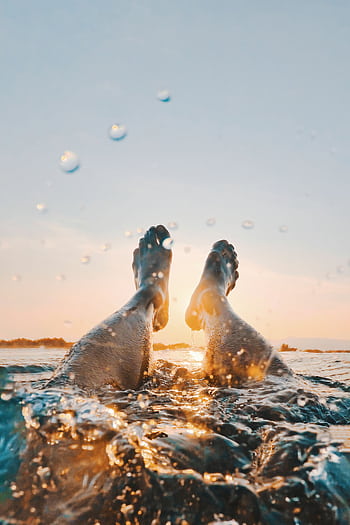 Enjoy a serene swim during sunset in Santa Cruz, Ilocos Region, Philippines, with stunning ocean views. HD phone wallpaper
