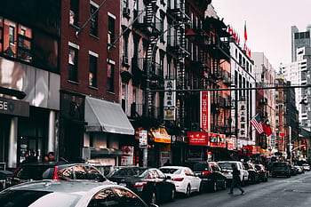 Busy urban street scene featuring traffic and city buildings in daylight, capturing vibrant urban life. HD wallpaper