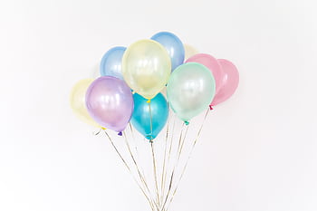 A cluster of colorful pastel balloons floating with a minimalistic white backdrop. HD wallpaper