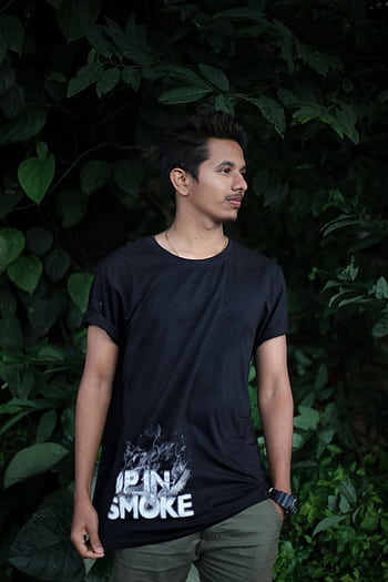 A young man poses casually outdoors against lush greenery in Bengaluru, India. HD phone wallpaper