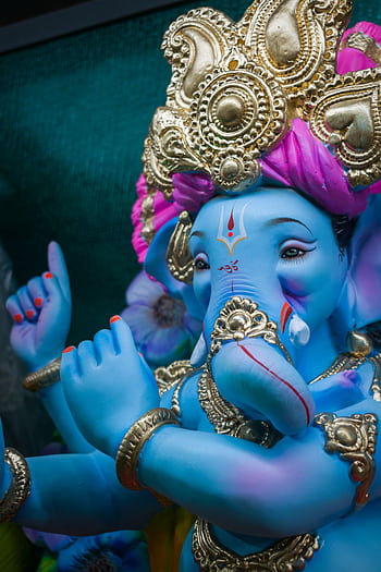 Vibrant depiction of Lord Ganesha statue adorned with gold and bright colors for the Ganesh Chaturthi festival. HD phone wallpaper