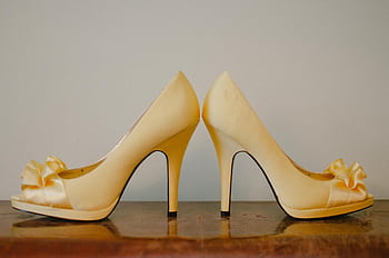 Chic yellow high heel shoes with bows, perfect for luxury fashion aesthetics. HD wallpaper