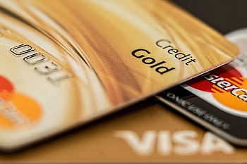 Stack of various branded credit cards focusing on gold card showing finance and cashless concept. HD wallpaper