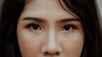 A detailed close-up showcasing the expressive eyes and natural beauty of a young woman. HD wallpaper