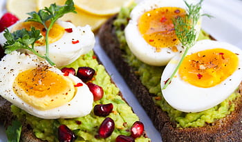 Savor this delicious avocado toast topped with soft-boiled eggs and garnished with pomegranate seeds. HD wallpaper