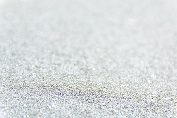 Close-up of defocused silver glitter creating a sparkling textured background. HD wallpaper