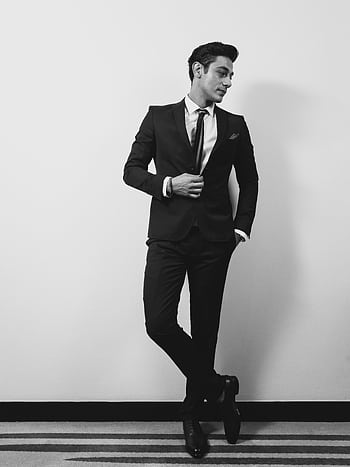 Black and white portrait of a sophisticated man in formal attire striking a confident pose. HD phone wallpaper