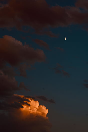 Serene twilight sky featuring a crescent moon and illuminated clouds, capturing a peaceful night scene. HD phone wallpaper