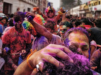 Colorful celebration of Holi Festival in Gorakhpur, India with joyful crowd covered in powders. HD wallpaper