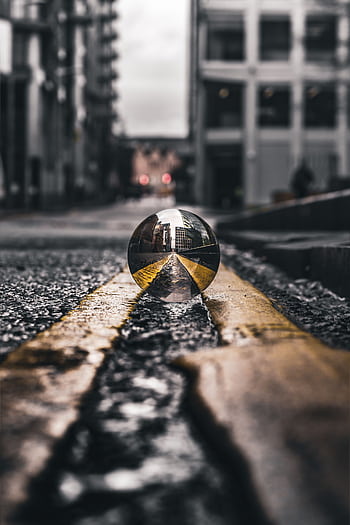 A crystal ball reflecting city architecture on a wet Manchester street. HD phone wallpaper