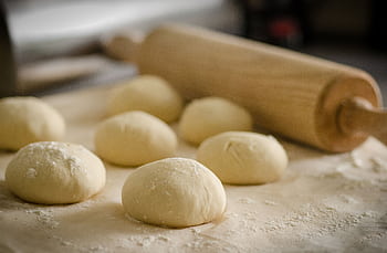 Close-up of freshly prepared dough balls ready for baking in a cozy kitchen. HD wallpaper
