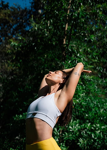 A woman in a yoga pose outdoors, symbolizing a healthy lifestyle and mindfulness. HD phone wallpaper
