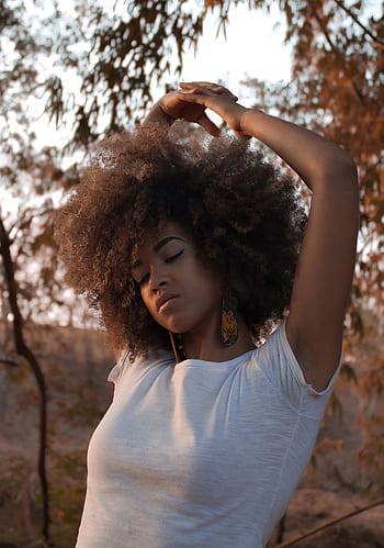 A serene portrait of a woman posing outdoors, embracing natural beauty with eyes closed. HD phone wallpaper