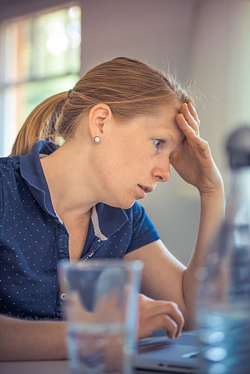 Businesswoman showing stress and concentration while working at her desk. HD phone wallpaper