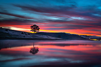 Stunning sunset over a tranquil lake with vibrant colors and a scenic landscape reflection. HD wallpaper