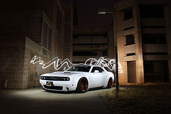 White luxury sports car parked with dynamic light trails at night against a building backdrop. HD wallpaper