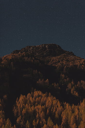 Explore a breathtaking view of a mountainous landscape under a starry night sky. HD phone wallpaper