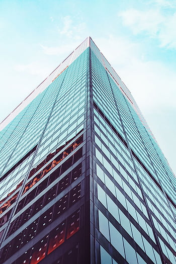 Low angle view of a modern skyscraper in New York City showcasing architectural design against a clear sky. HD phone wallpaper