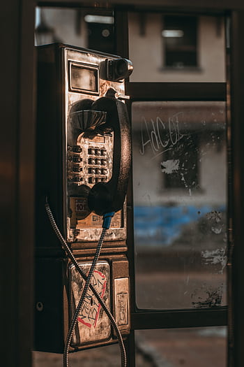 A vintage tele booth with a rusty exterior on an urban street. HD phone wallpaper