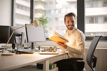 A relaxed businessman enjoying a break in his bright, contemporary office environment. HD wallpaper