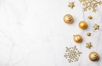 Elegant golden Christmas ornaments on a marble surface, perfect for festive backgrounds. HD wallpaper