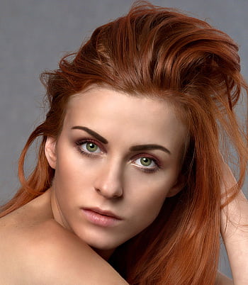 Close-up portrait of a woman with striking red hair and green eyes, exuding elegance. HD phone wallpaper