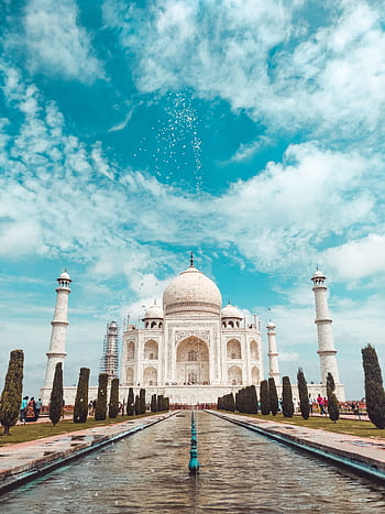 A majestic view of the iconic Taj Mahal under a bright, blue sky with clouds. HD phone wallpaper