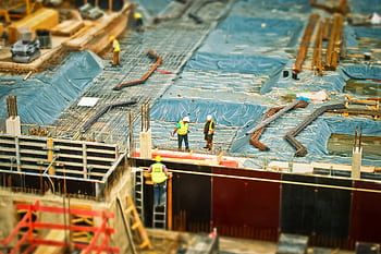 High-angle view of construction workers on a building site, engaging in construction work. HD wallpaper