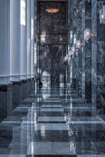 Sleek modern hallway featuring marble walls and floor with reflective surfaces and soft lighting. HD phone wallpaper