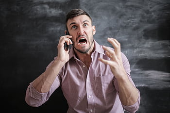 A distressed man in a pink shirt expressing frustration while using a smart indoors. HD wallpaper
