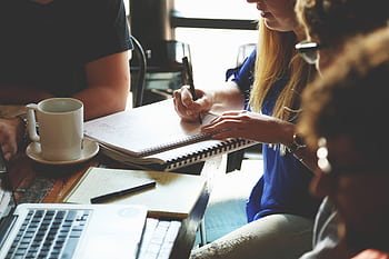 A group of young adults working together on a project at a casual meeting. HD wallpaper