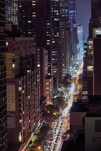 Stunning cityscape of New York at night with illuminated skyscrapers and light trails. HD phone wallpaper