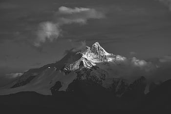 Stunning black and white of a snow-capped mountain peak in Tibet, enveloped in clouds. HD wallpaper