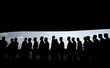 Silhouettes of people in line under a shaded canopy, highlighting social interaction and society. HD wallpaper