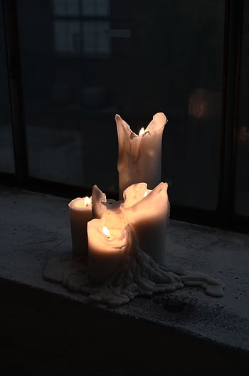 A group of melting candles casting a warm glow on a window sill in the evening darkness. HD phone wallpaper