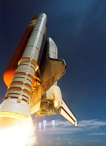 Dynamic low angle view of a space shuttle launch highlighting rocket boosters igniting for space travel. HD phone wallpaper