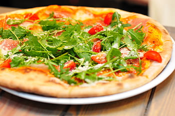 Delicious homemade pizza topped with fresh arugula, tomatoes, and parmesan cheese. HD wallpaper