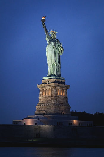 Stunning nighttime view of the Statue of Liberty on Liberty Island, New York City. HD phone wallpaper