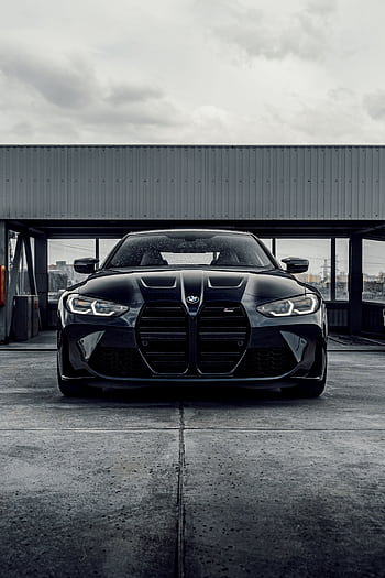 A sleek black luxury car parked in an industrial urban setting, showcasing modern design and elegance. HD phone wallpaper