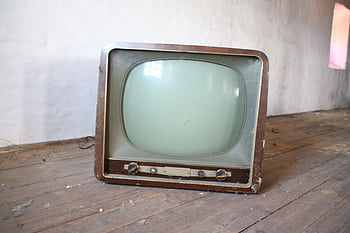 Vintage wooden television sitting on a dusty, rustic wooden floor in an abandoned room. HD wallpaper