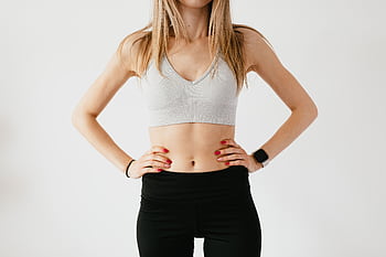 A fit woman's torso in activewear, displaying fitness and wellness on a white background. HD wallpaper