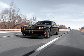 High-performance black car driving fast on a highway with dynamic motion blur. HD wallpaper