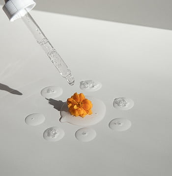 A flower surrounded by drops of liquid with a dropper, showcasing beauty and skincare concepts. HD phone wallpaper