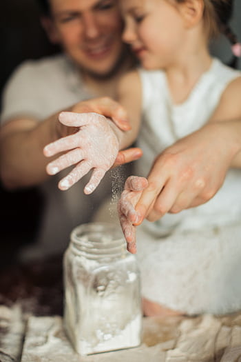 Father and daughter enjoy a joyful baking session, creating memories together. HD phone wallpaper