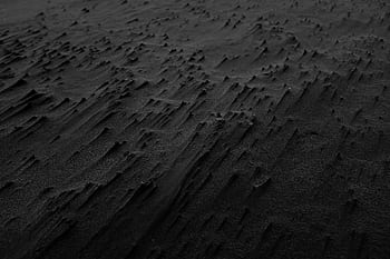 Abstract black sand texture creating a dramatic and moody background. HD wallpaper