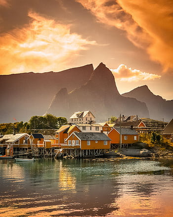 Scenic view of a colorful village by the fjord against a dramatic sunset in Vågan, Nordland, Norway. HD phone wallpaper